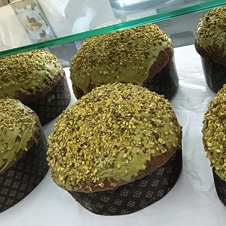 Panettoni al pistacchio glassati allineati in vetrina