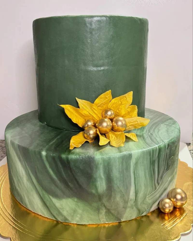 Torta scenografica a due piani verde marmorizzata con fiore dorato