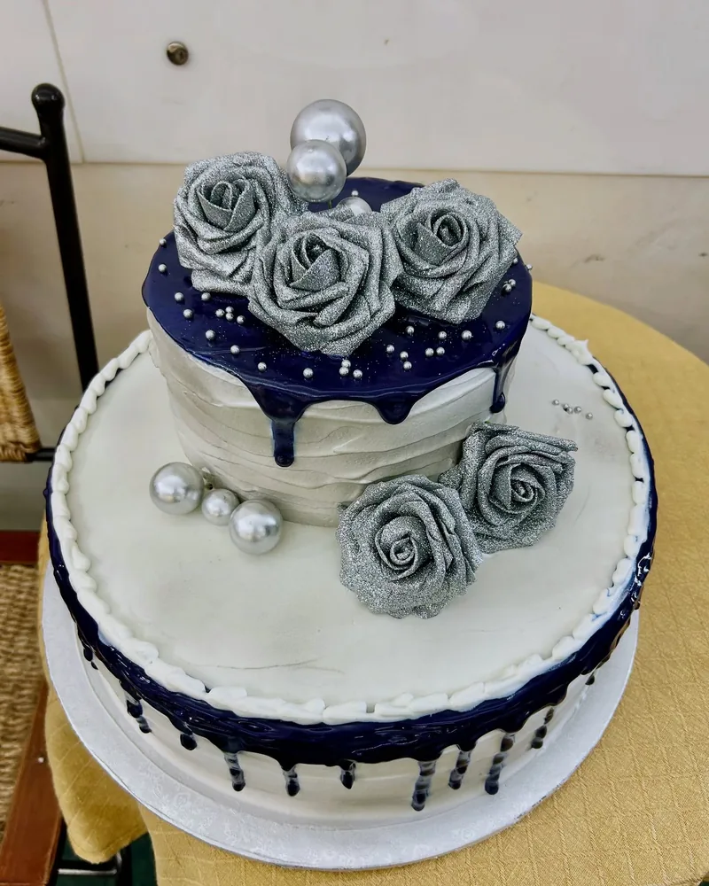 Torta a due piani blu notte con rose argentate e perle