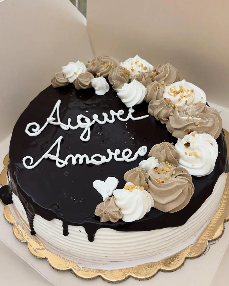 Torta al cioccolato con ciuffi di crema e scritta a mano