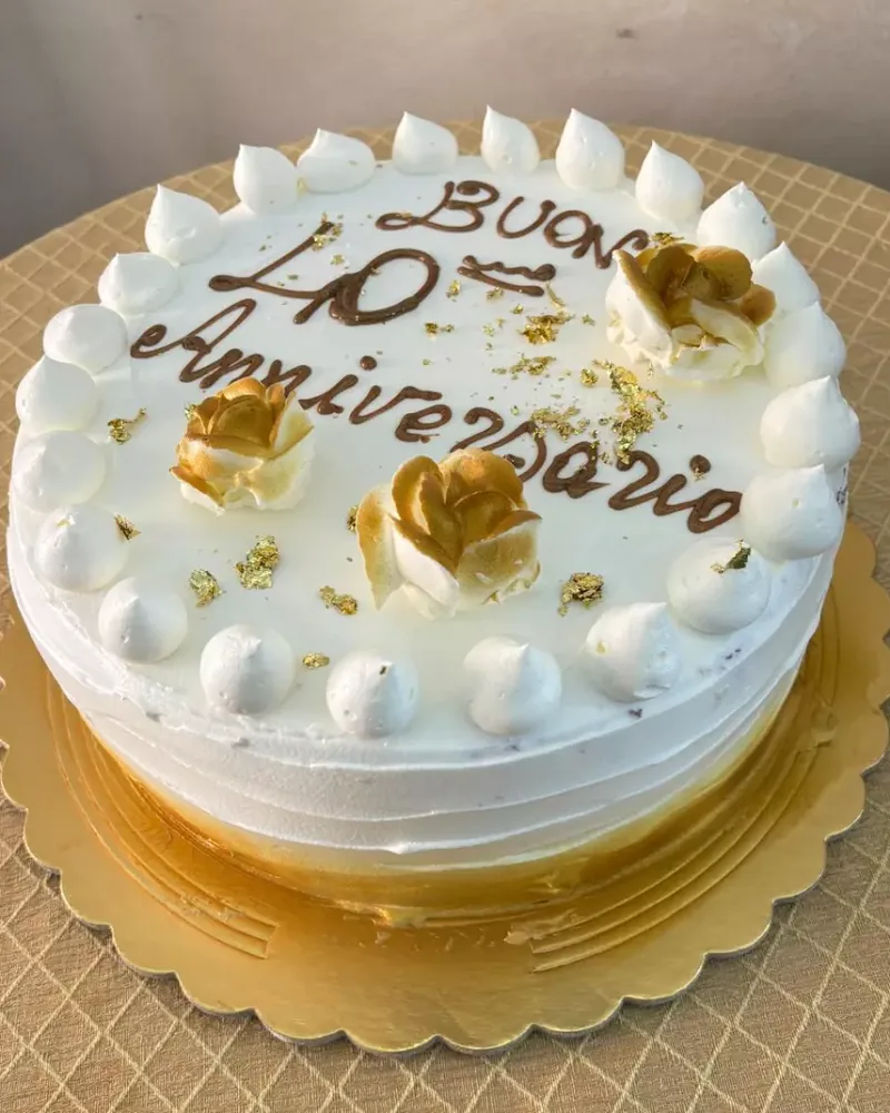 Torta bianca da anniversario con rose dorate